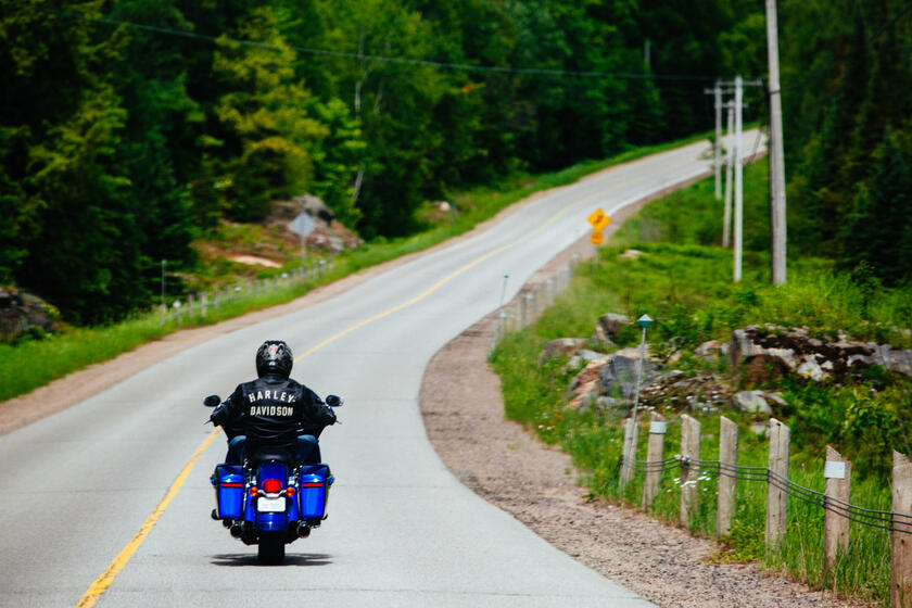 man riding motorcycle on forest road