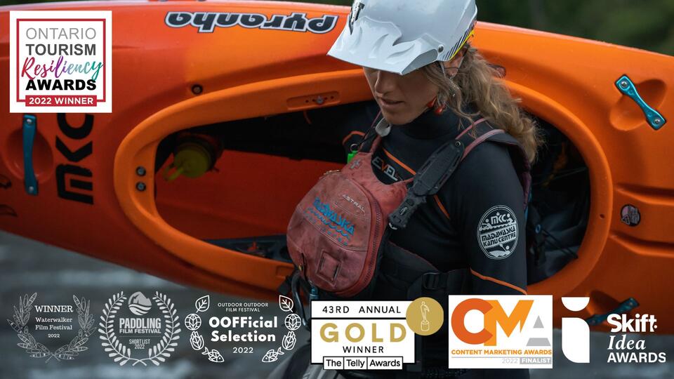 Still photography for the Connected to Water Episode. A woman in kayak gear carrying a kayak.