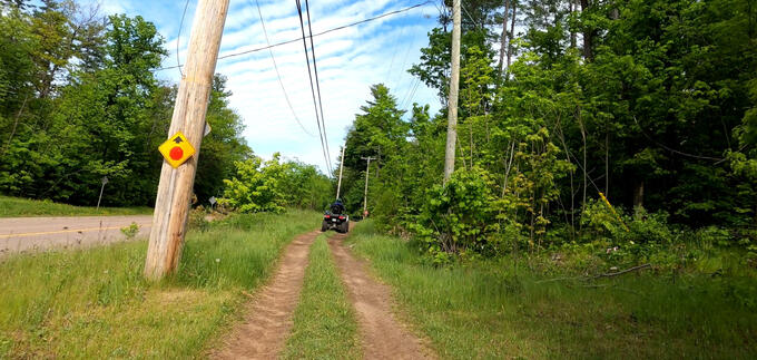 An ATV is stopped on a grassy trail.