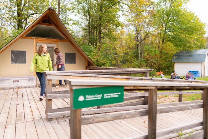 A woman and man exit an OTentik at Parks Canada.