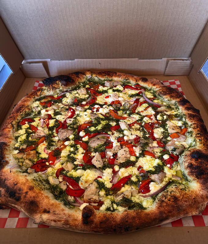 A pizza is shown inside an open pizza box.